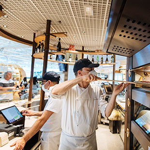 Un pizzaiolo inforna una pizza all’interno del ristorante Eataly.